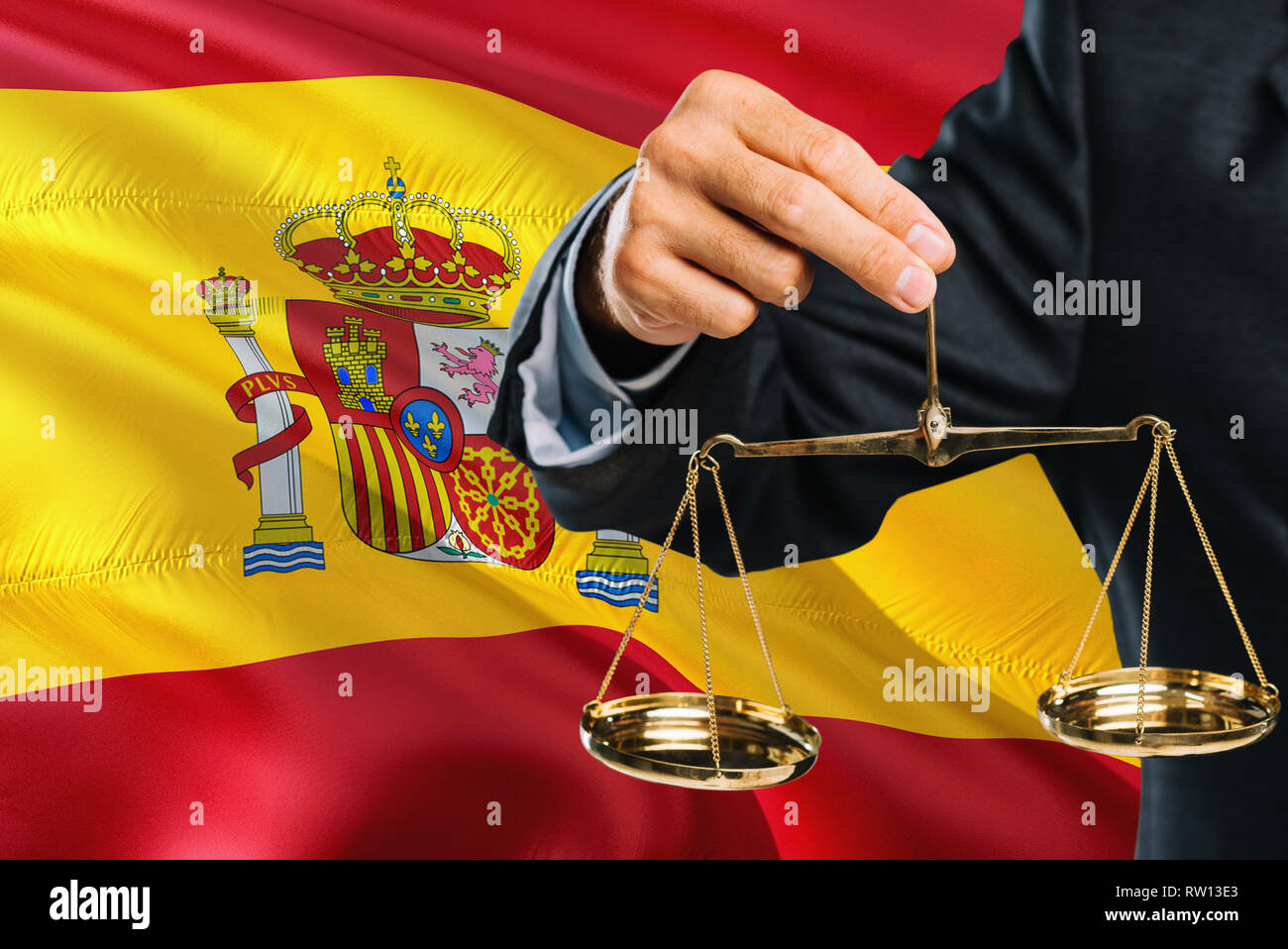 Spanish Judge is holding golden scales of justice with Spain waving