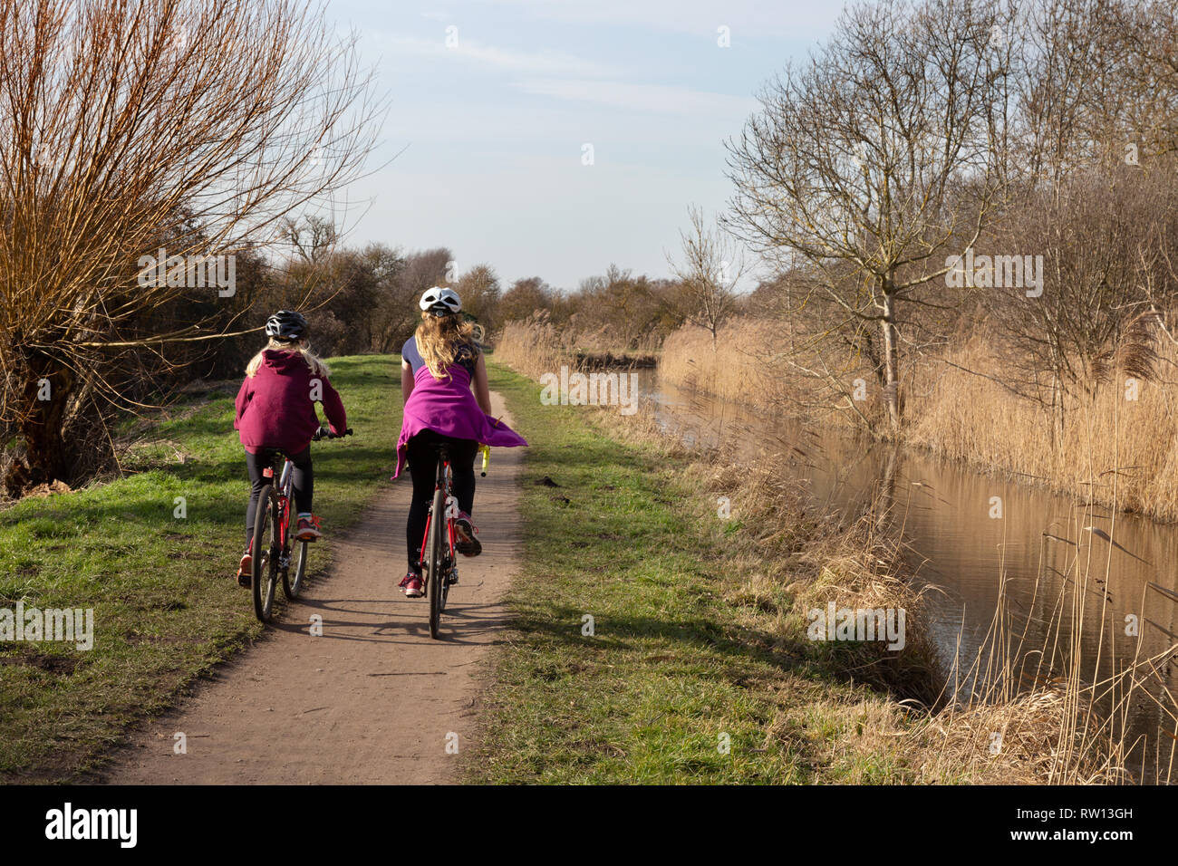 women cycling in the UK countryside in Cambridgeshire fens, East Anglia UK Stock Photo