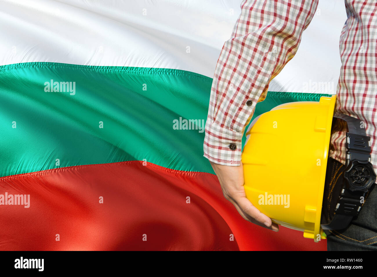 Bulgarian Engineer is holding yellow safety helmet with waving Bulgaria