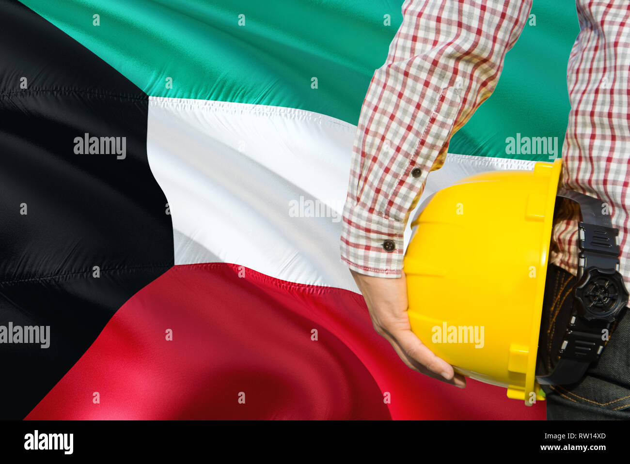 Kuwaiti Engineer is holding yellow safety helmet with waving Kuwait