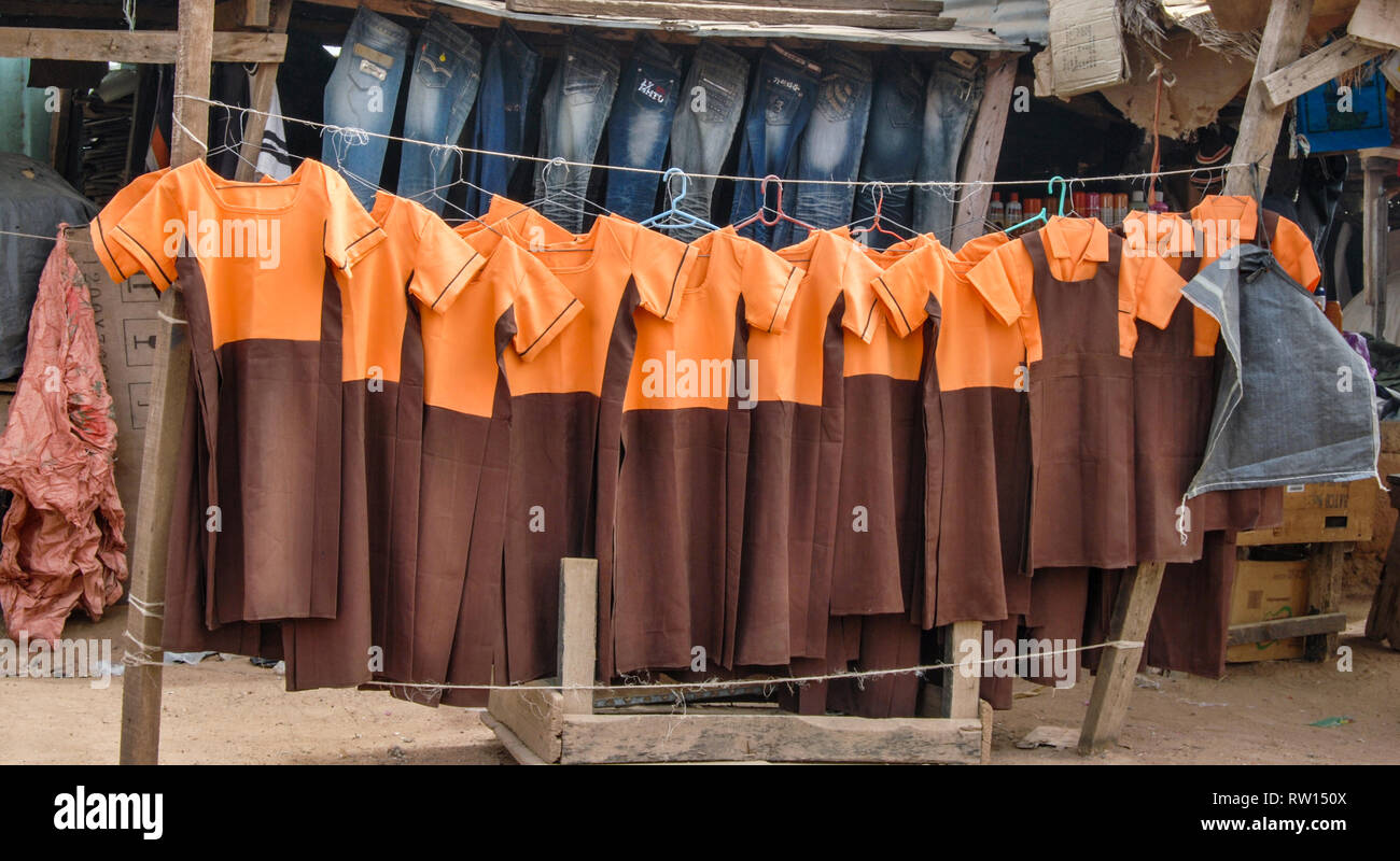 A local shop or stand selling blue jeans and orange and brown school uniforms in Bolgatanga, Ghana. Stock Photo