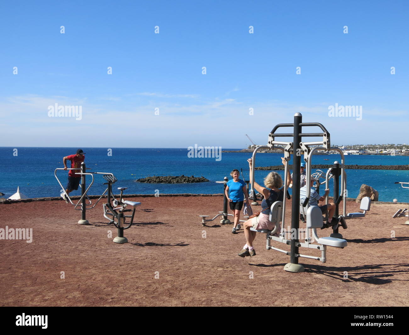 People Enjoying A Range Of Outdoor Exercise Equipment On The