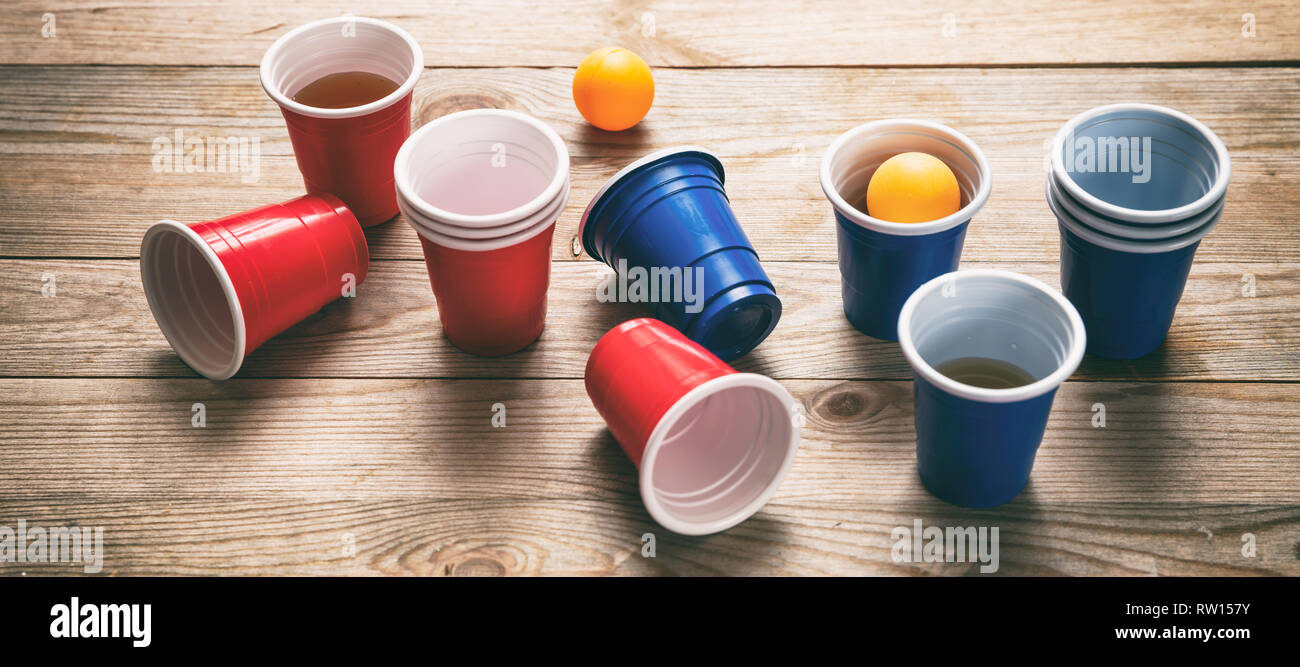 https://c8.alamy.com/comp/RW157Y/beer-pong-college-party-game-plastic-red-and-blue-color-cups-and-ping-pong-balls-on-wooden-background-banner-RW157Y.jpg