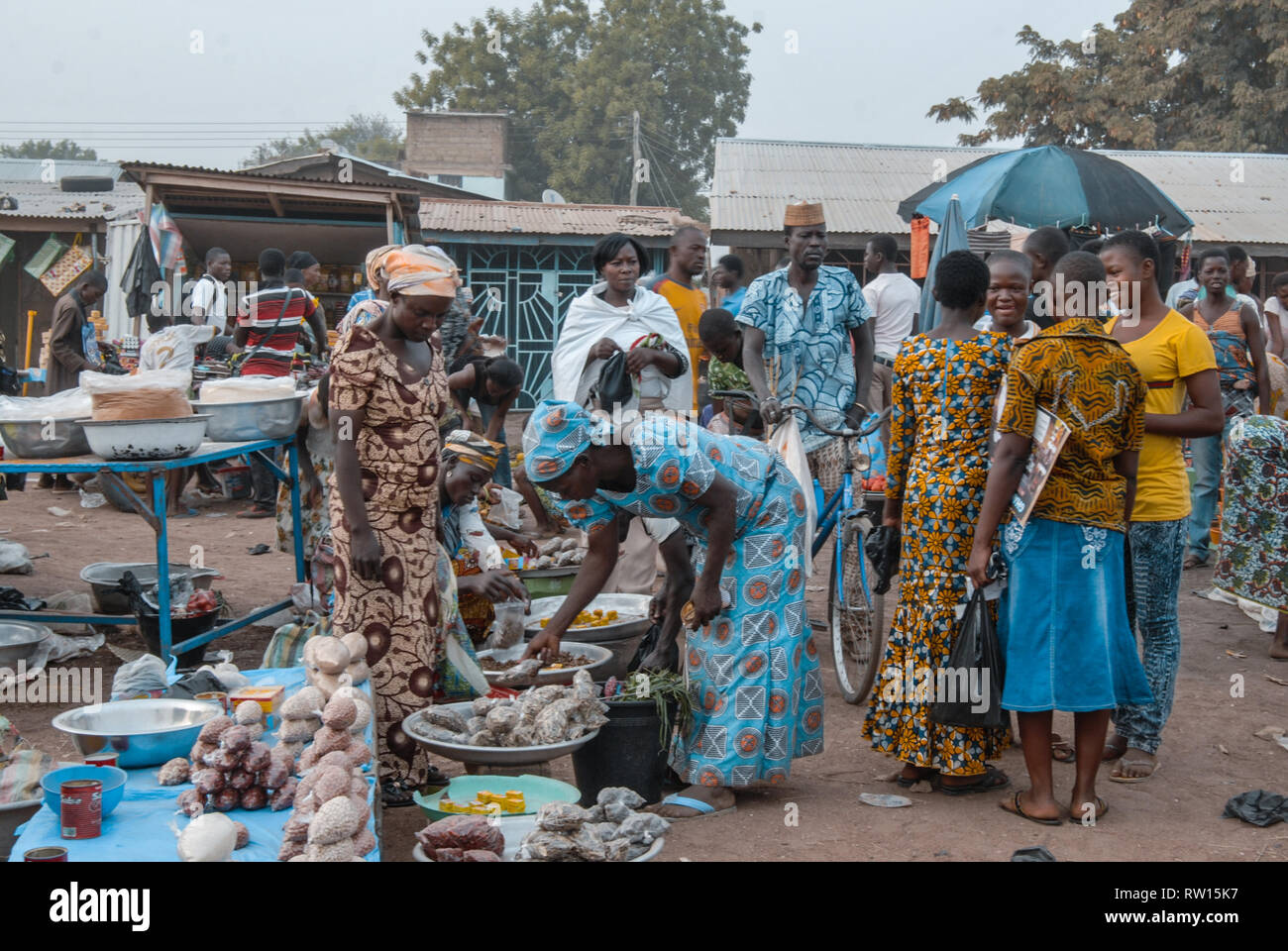 A nice colorful photo of local Ghanaian people wearing traditional clothes visiting the fresh market and socializing. Stock Photo