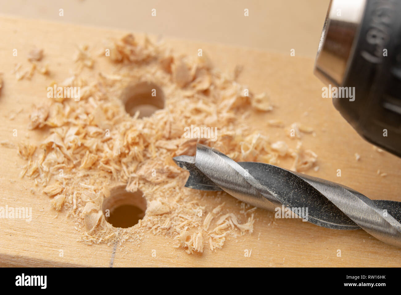 Drilling a hole in wood. Wood drill and plywood in a carpentry