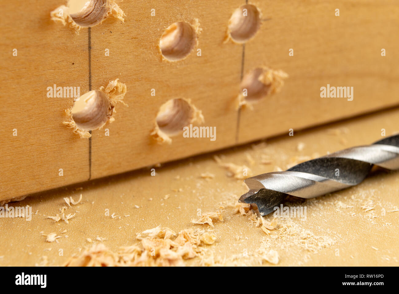 Drilling a hole in wood. Wood drill and plywood in a carpentry
