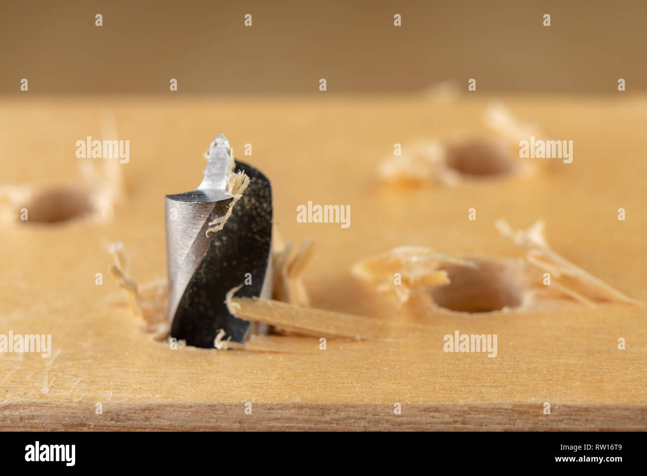 Drilling a hole in wood. Wood drill and plywood in a carpentry