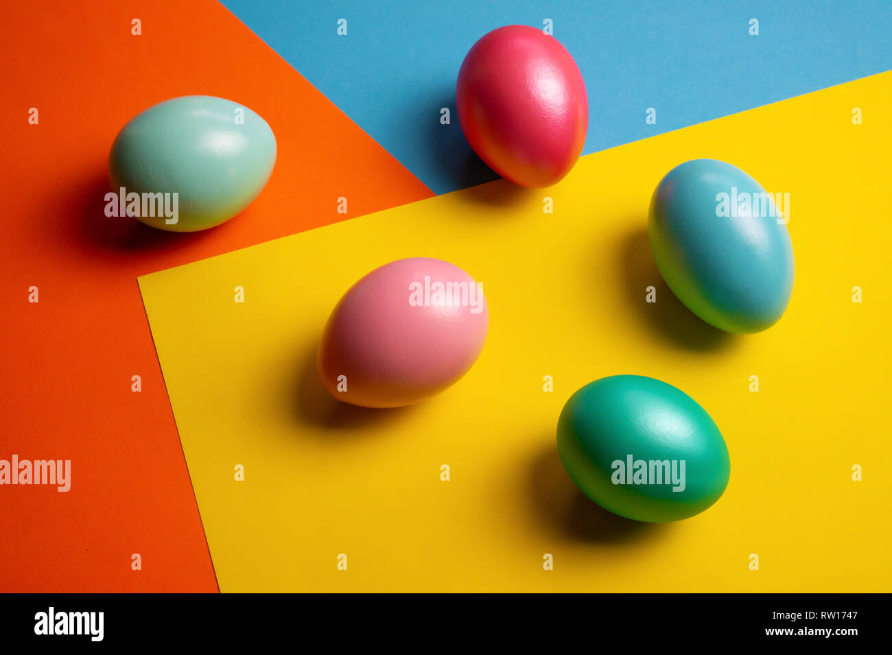 Colorful shiny easter eggs on color block background Stock Photo