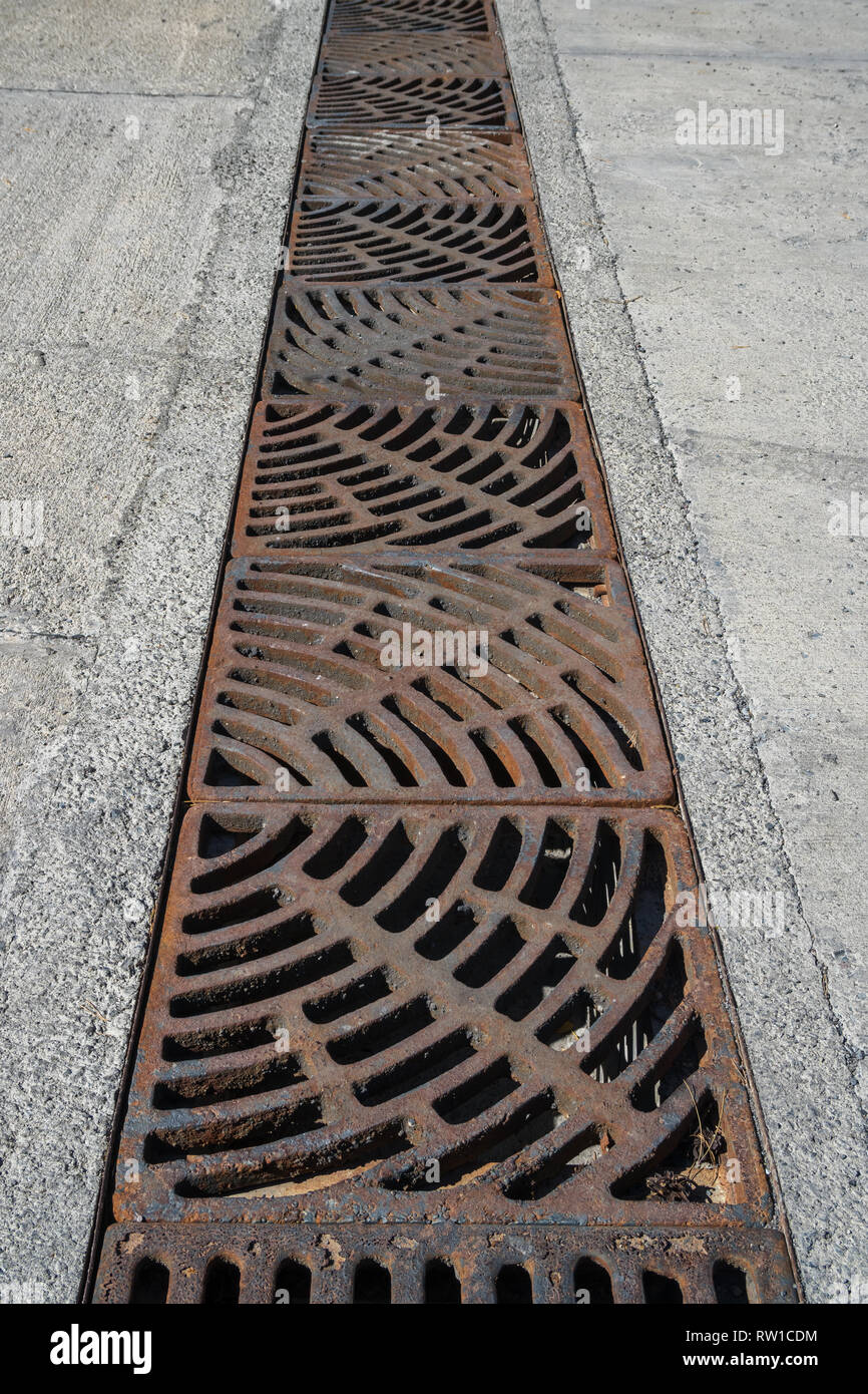Drain of metal grate around with rough beton road surface Stock Photo Alamy