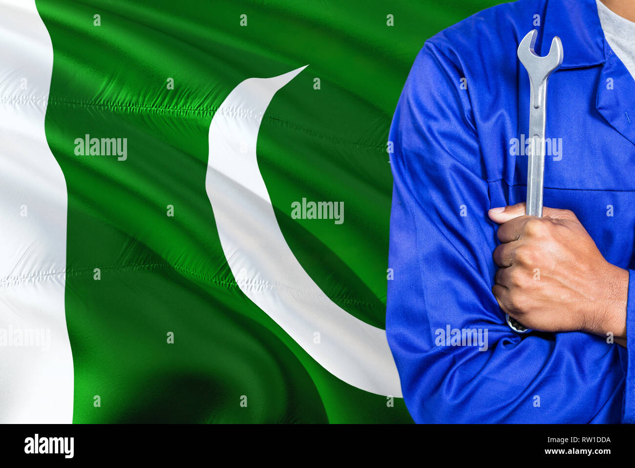Pakistan Mechanic Robe Pakistani Mechanic in blue uniform is holding wrench against waving ...