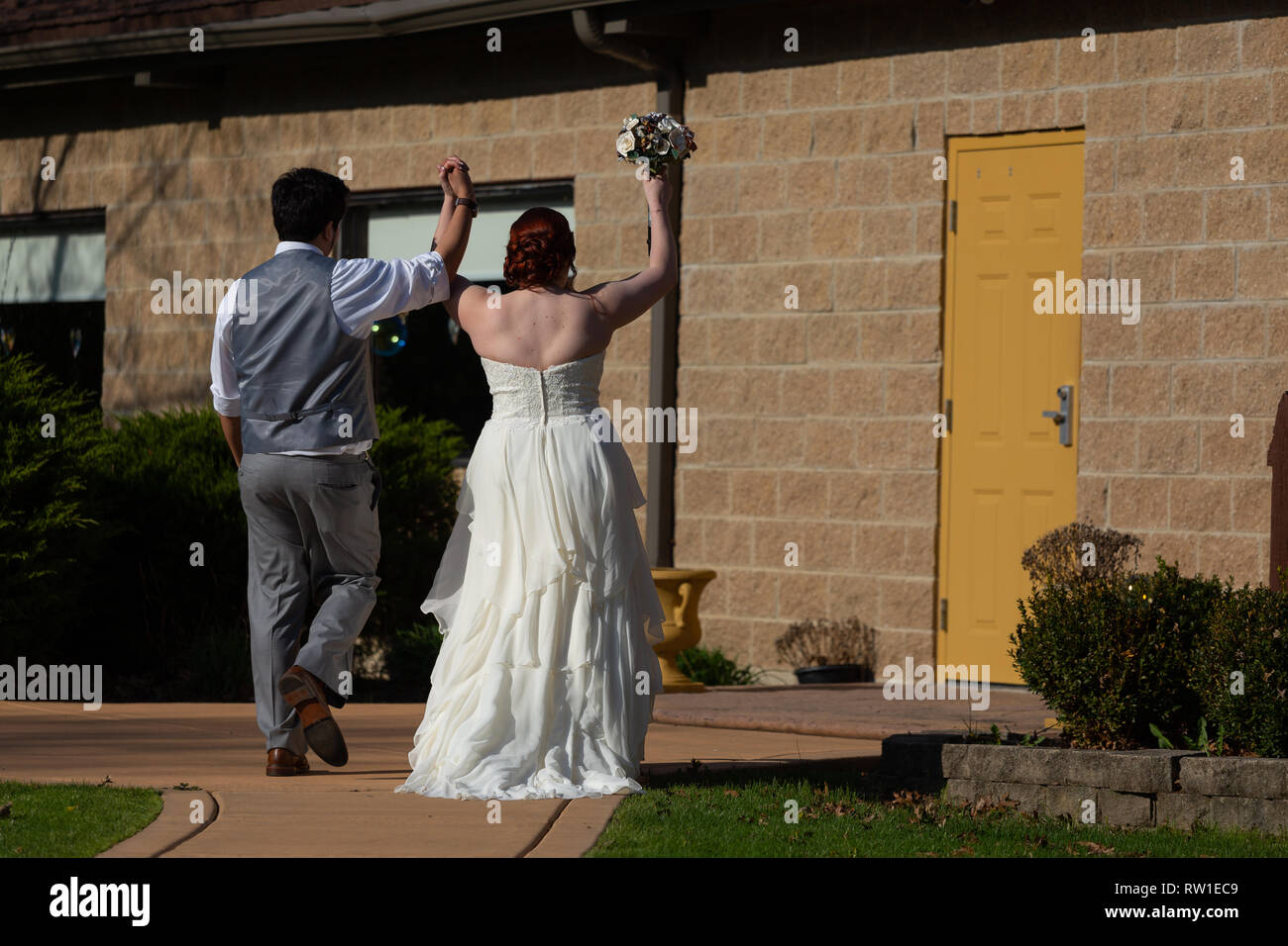 Bride and groom walking together celebrating after wedding ceremony Stock Photo