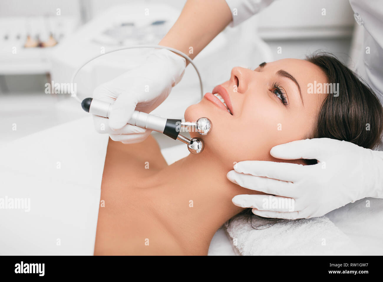 Beautiful woman receiving facial microcurrent procedure for lifting face. facial rejuvenation and facelift with microcurrent therapy Stock Photo