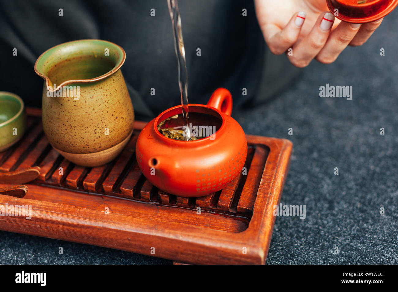 Traditional tea ceremony close up. Unrecognizable woman pours boiling