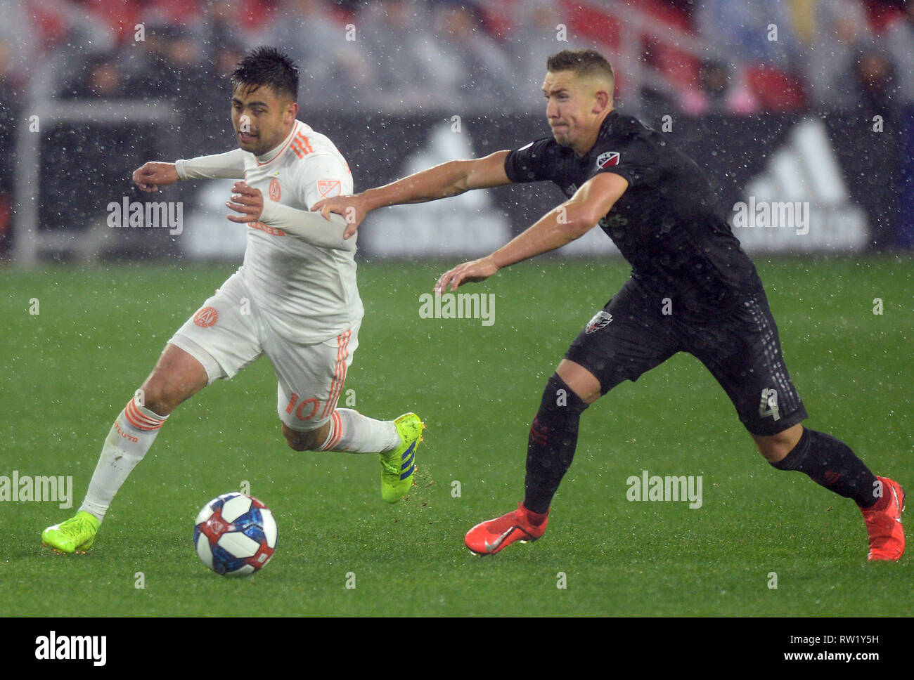 Washington, DC, USA. 3rd Mar, 2019. 20190303 - Atlanta United FC midfielder MIGUEL ALMIRON (10) swings the ball around D.C. United midfielder RUSSELL CANOUSE (4) during a steady rain in the second half at Audi Field in Washington. Credit: Chuck Myers/ZUMA Wire/Alamy Live News Stock Photo
