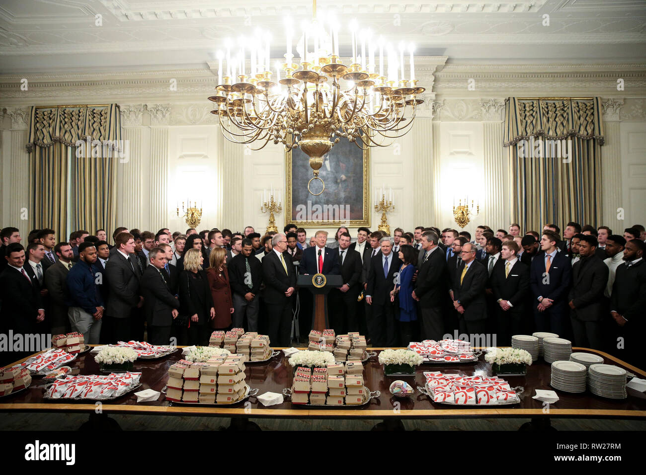 Washington, DC. 4th Mar, 2019. United States President Donald J. Trump speaks behind a table full of McDonald's hamburgers, Chick fil-a sandwiches and some other fast food as he welcomes the 2018 Division I FCS National Champions: The North Dakota State Bison in the Diplomatic Room of the White House on March 4, 2019 in Washington, DC. Credit: Oliver Contreras/Pool via CNP | usage worldwide Credit: dpa/Alamy Live News Stock Photo