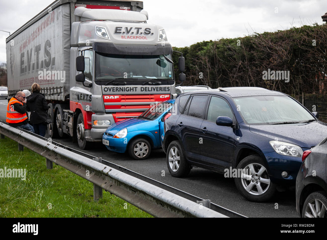 HGV traffic accident with car on dual carriageway; TRC on the A565 Gravel lane roundabout between DAF heavy goods vehicle and small Ford compact family car which ended up being pushed sideways down the road. Stock Photo