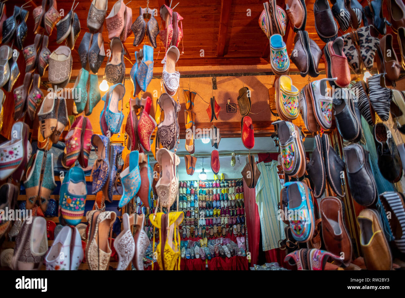 Various babouches, Moroccan slippers, hang in front doorway shop in medina quarter of Marrakesh, Morocco Stock Photo