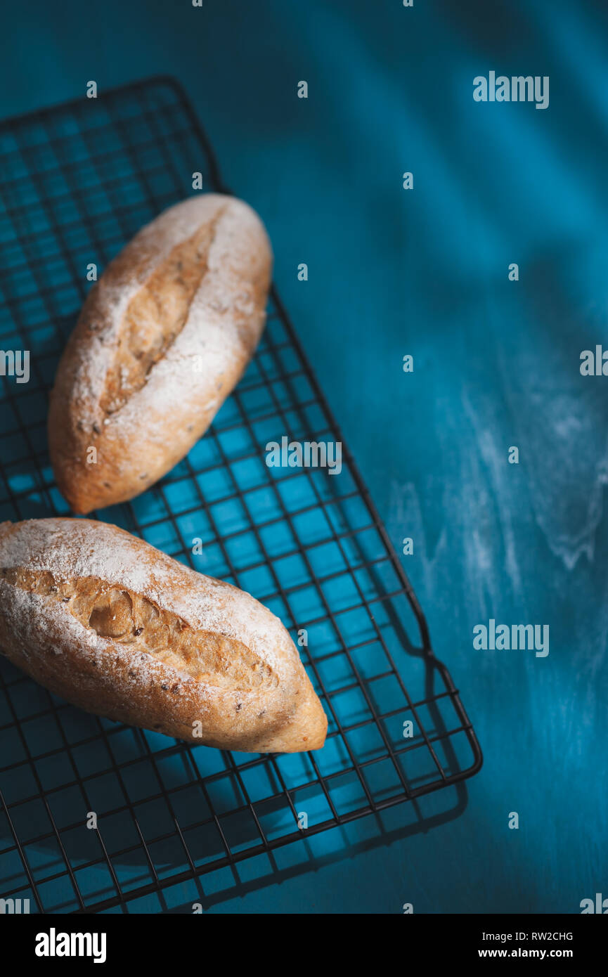 Baguette, European style bread on blue wood table in morning time with hard light effect. Organic and healthy meal in minimal style concept Stock Photo