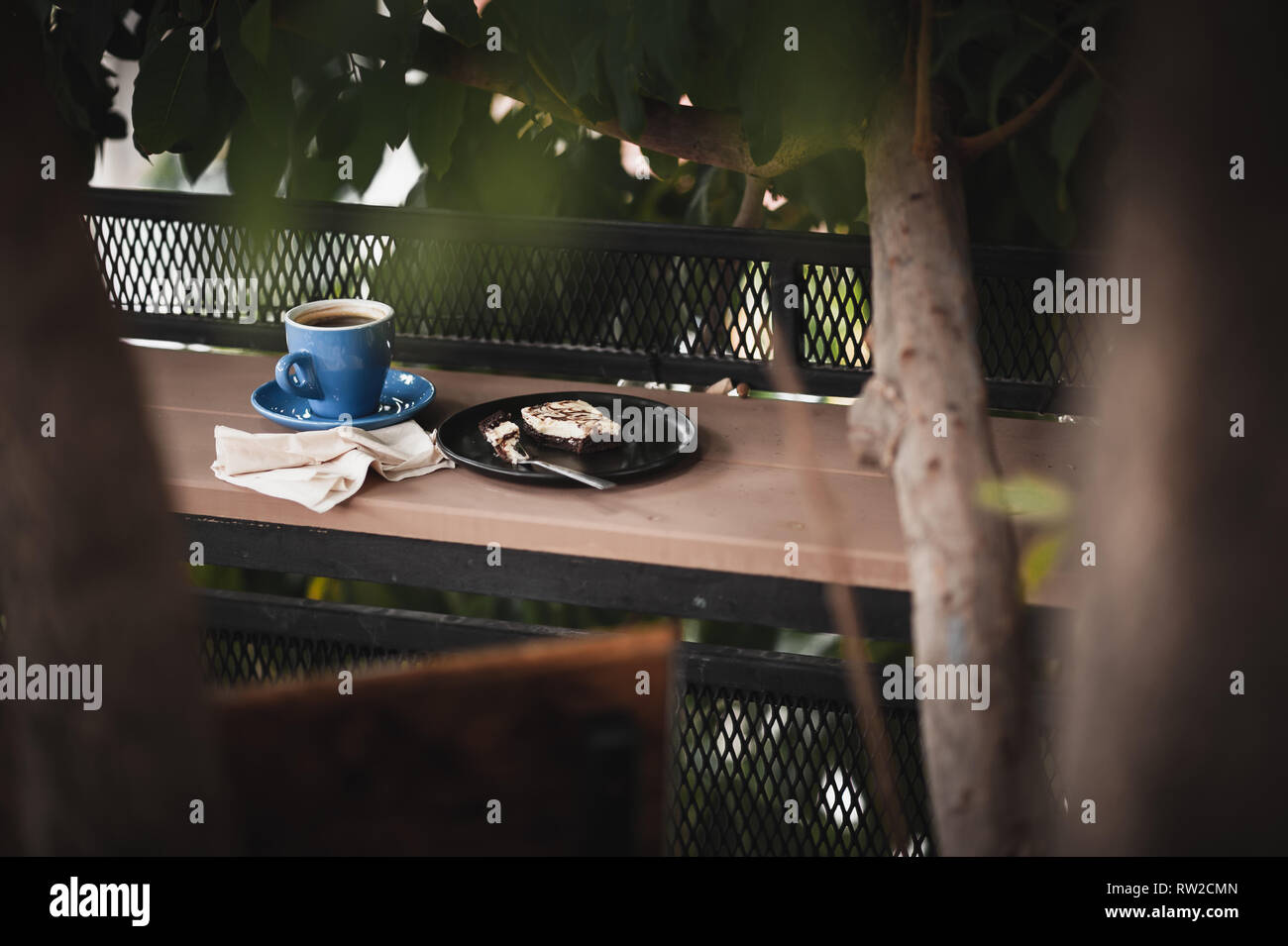 Abstract scene of coffee break meal set including black coffee, and brownie cheese cake on outdoor wood bar. Weekend morning activity with good emotio Stock Photo