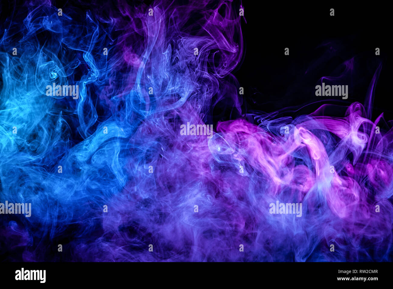 Close up swirling purple and blue smoke on black isolated background Stock Photo