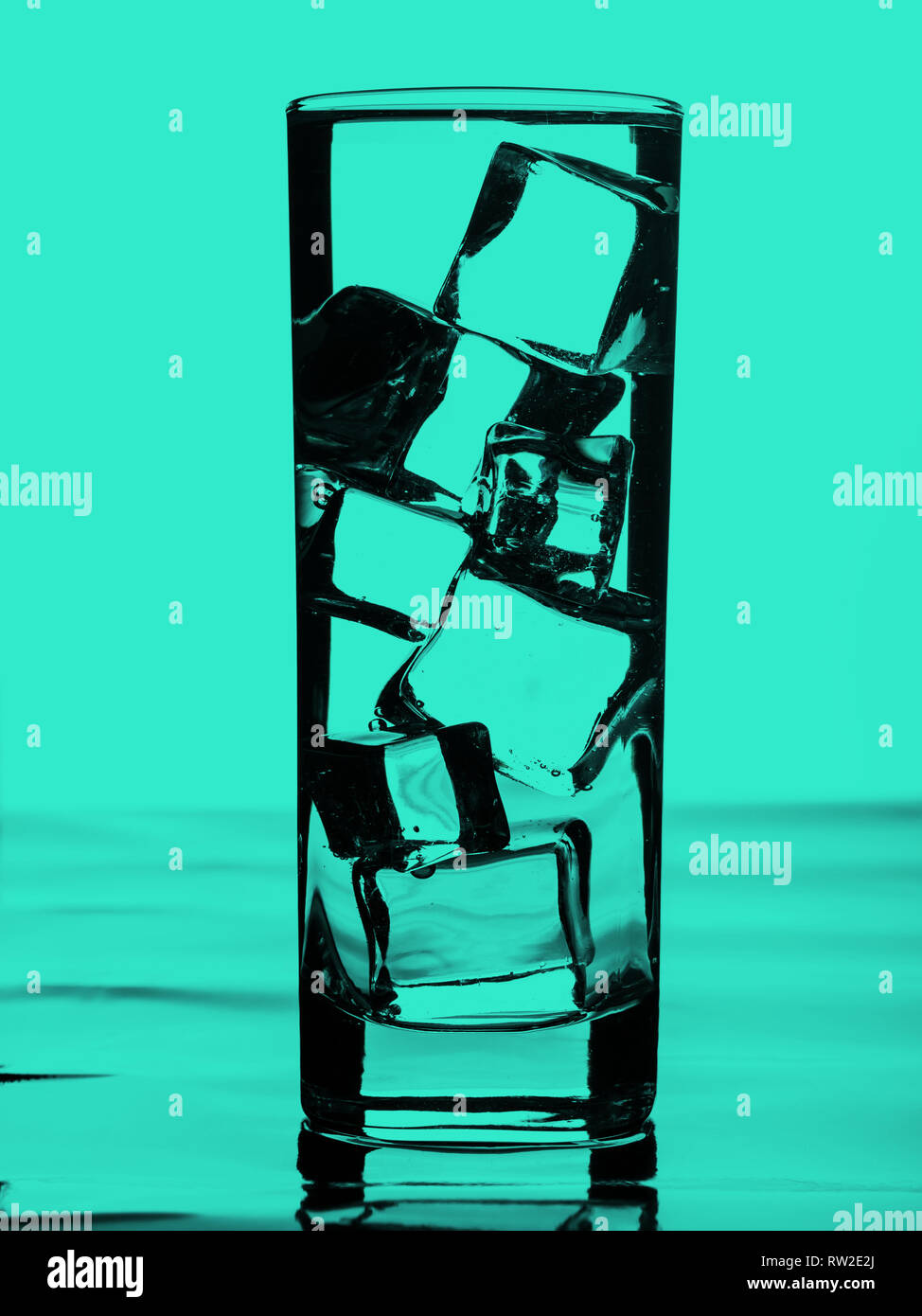 Glass of water with ice cubes. Emerald green toned Stock Photo - Alamy