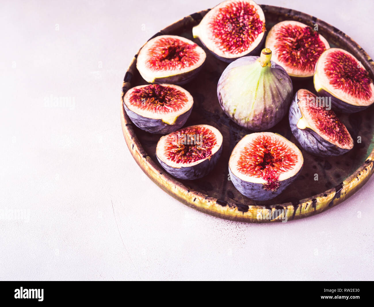 Dish of purple figs on stone background. Toned Stock Photo - Alamy
