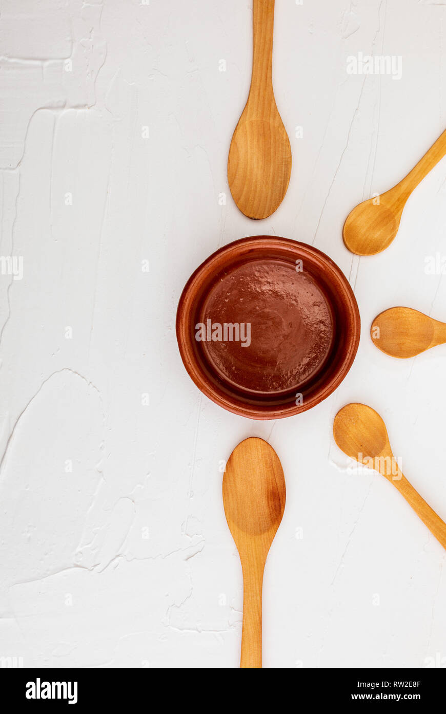 Crockpot and wooden spoons on white background with texture. Space to ...