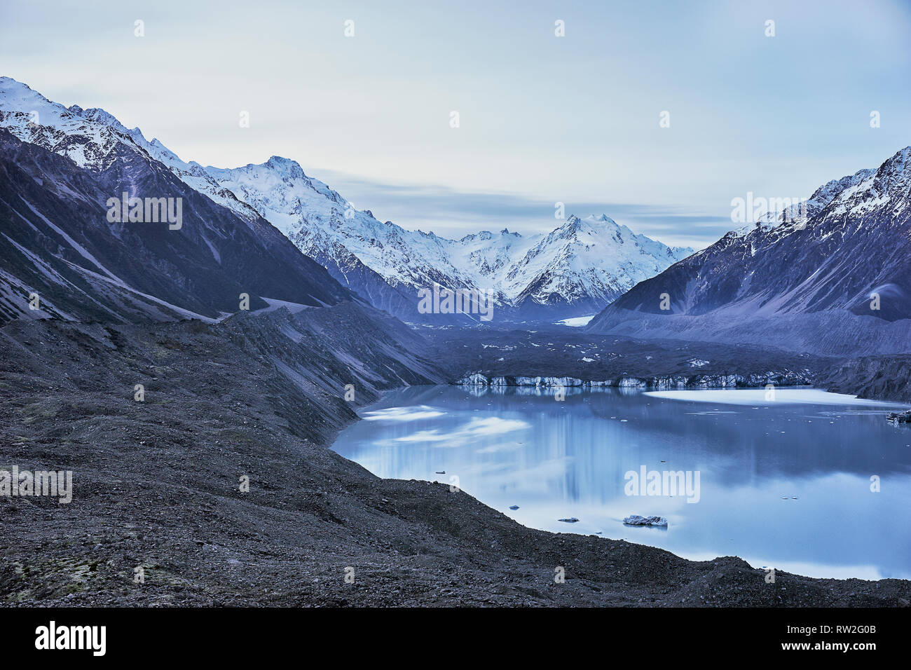 Cold winter morning in mountain with snow-covered peaks.  Splendid outdoor scene of Mount Cook. Beautiful light blue Tasman Glacier Lake. Stock Photo