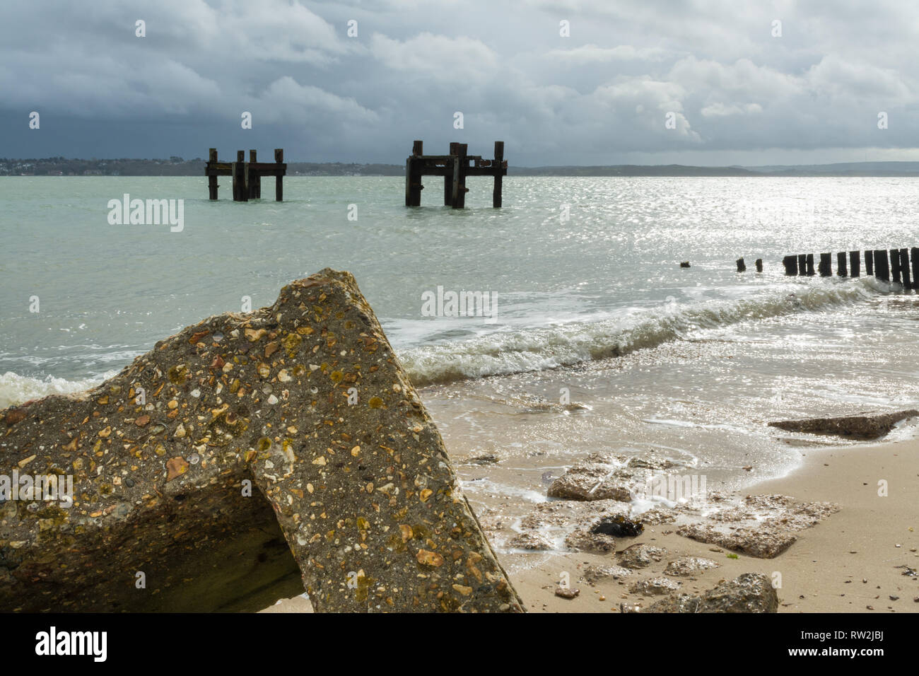 The remains of structures called the dolphins in the sea off of Lepe beach, part of the pierhead used on D-Day in world war 2, Hampshire, UK Stock Photo