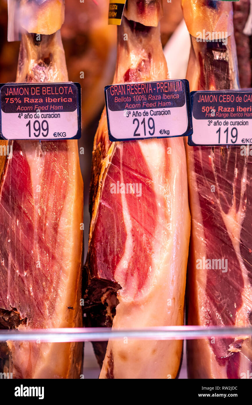 Jam—n IbŽrico de Bellota hams hanging at La Boqueria Food Market in Barcelona ,Spain. Spanish ham from acorn fed pigs is considered to be the finest h Stock Photo