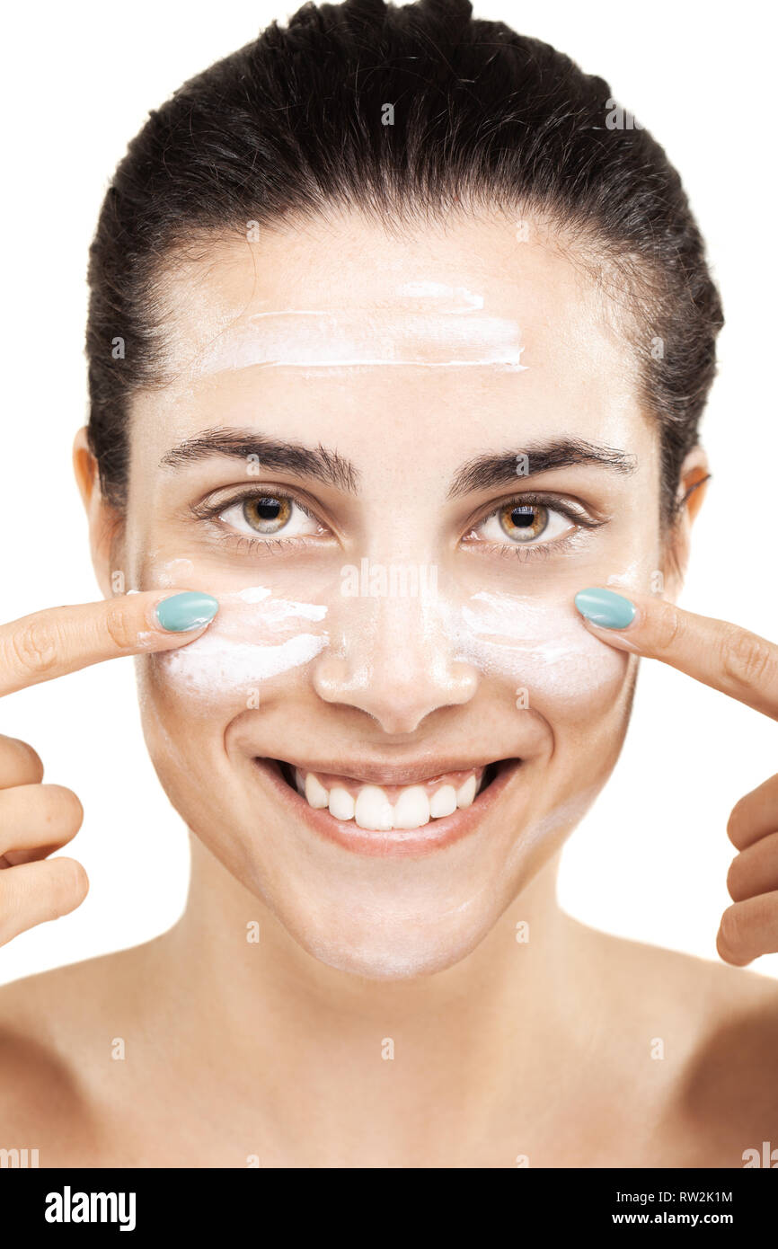 beautiful girl putting cream on her face with a smile Stock Photo Alamy