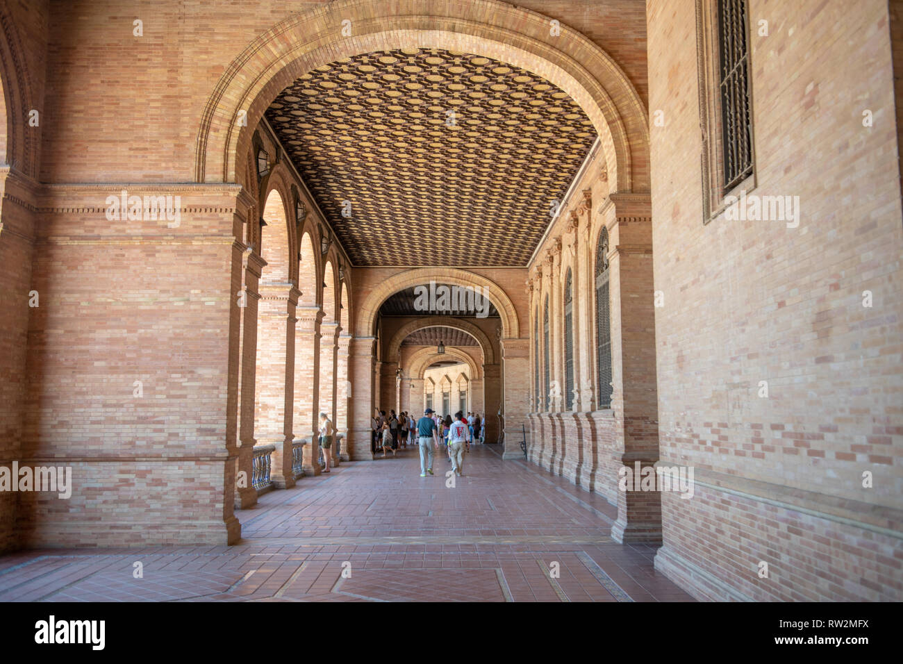 Tourist walk under cove walkway at the Plaza de Espa–a -Seville , Spain Stock Photo