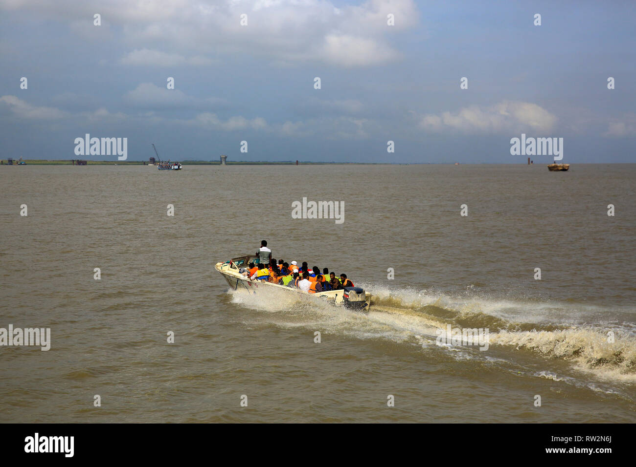 People cross the Padma River on speedboats on the Maowa-Kaorhakandi route. Munshiganj, Bangladesh Stock Photo