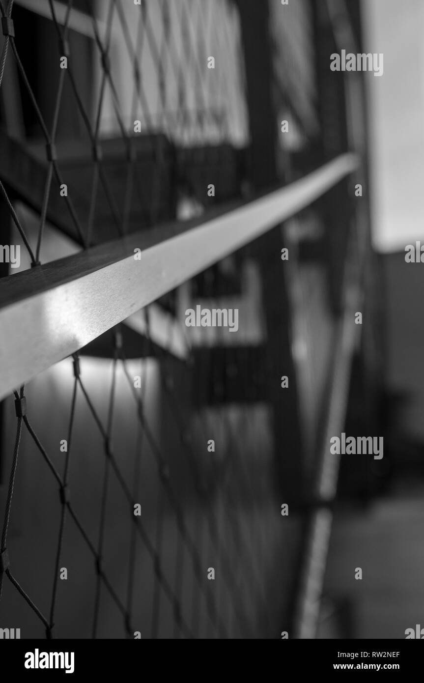 Black and White Macro Shot of an outdoor metal railing with light reflecting off its surfaces Stock Photo