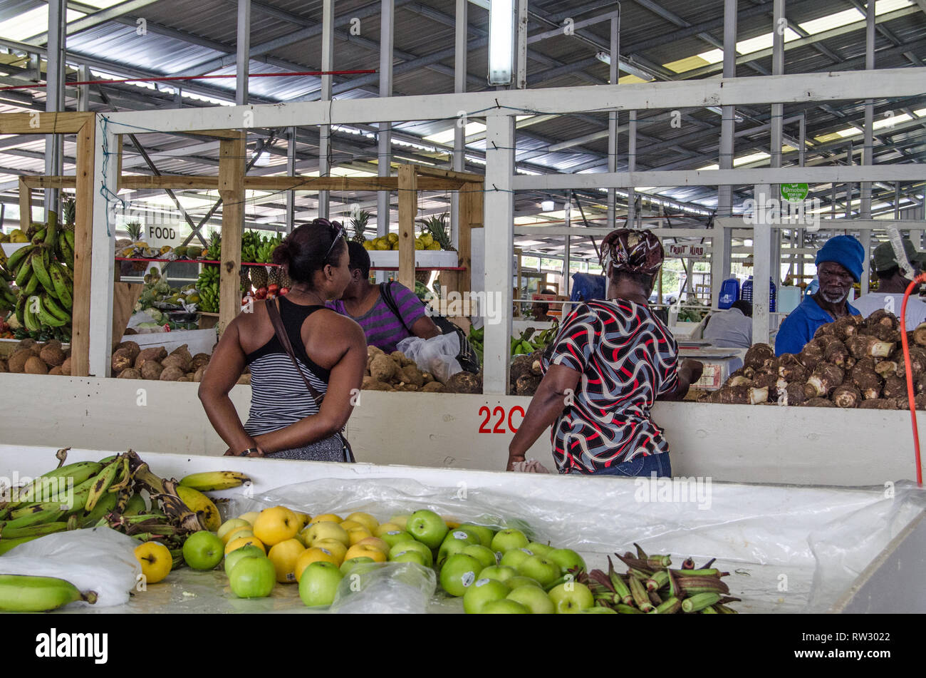 SCARBOROUGH, TRINIDAD AND TOBAGO - JANUARY 11, 2019:  Shoppers perusing the fresh produce on sale at the covered market in Scarborough, Tobago. Stock Photo