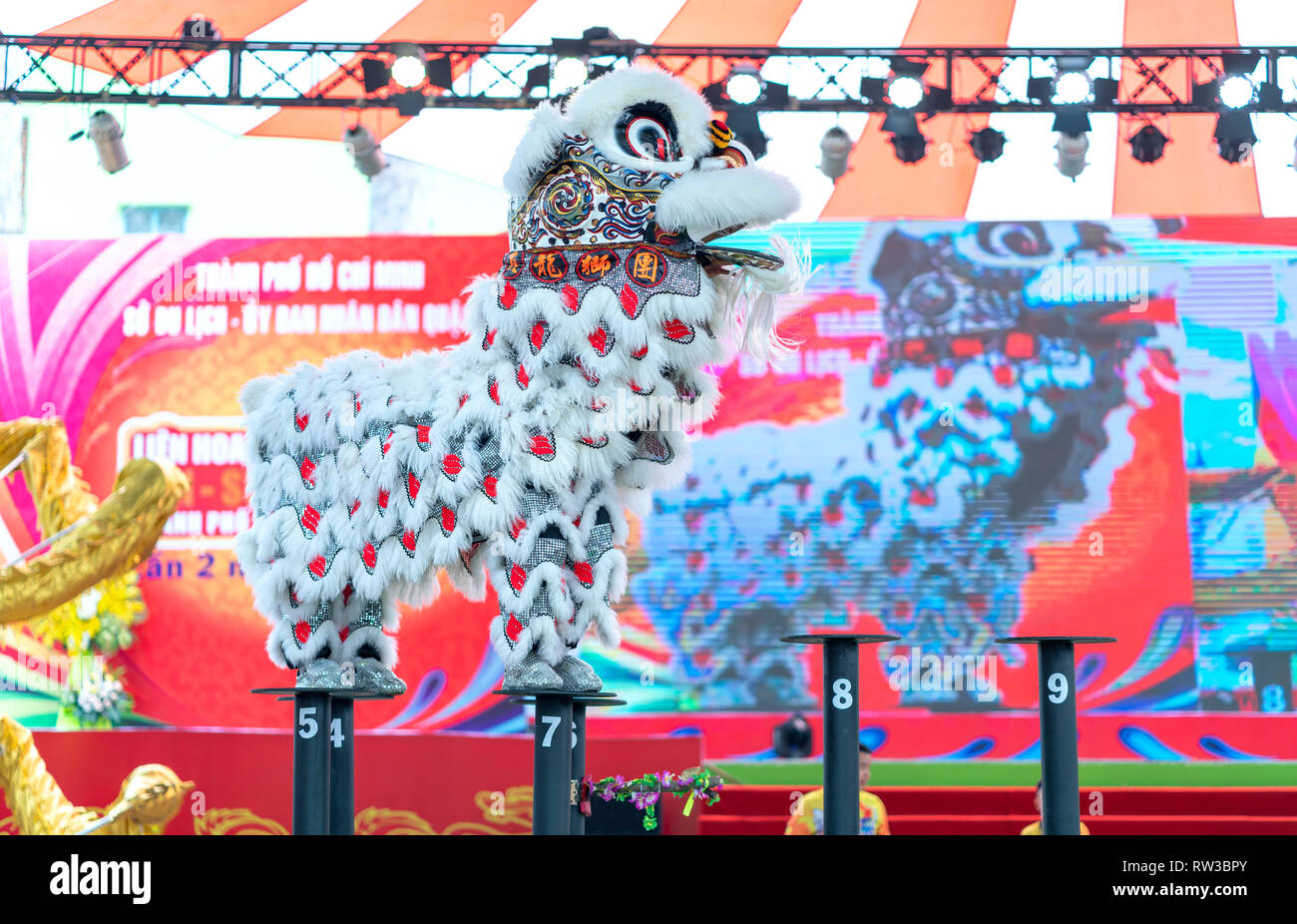 Practitioners in costume lion dancing perform on stage in Van Lang Park, District 5, to pray, safety and luck in new year attract visitors to see Stock Photo