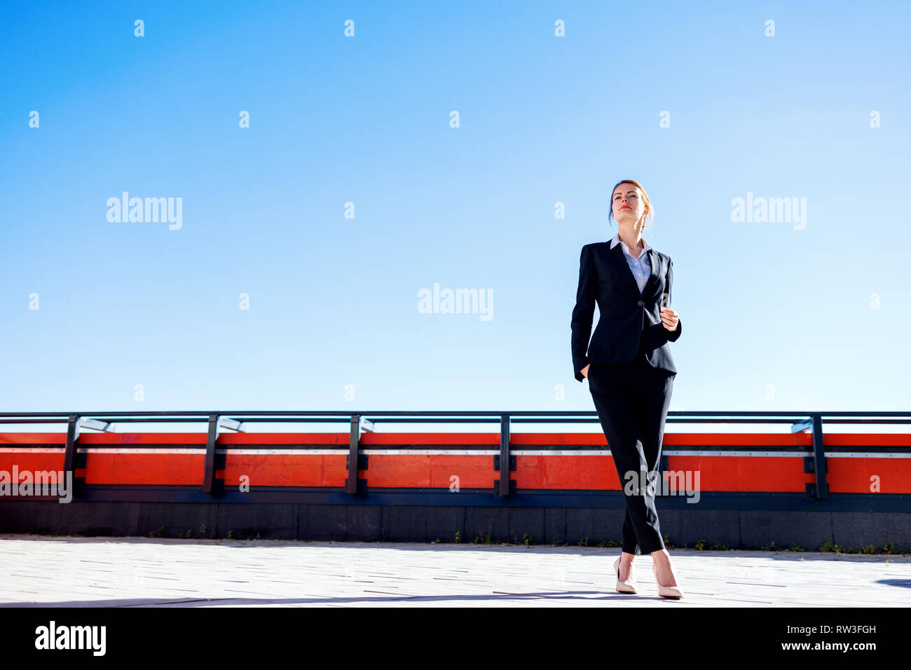 Business woman stands on observation deck over Moscow city background. Stock Photo