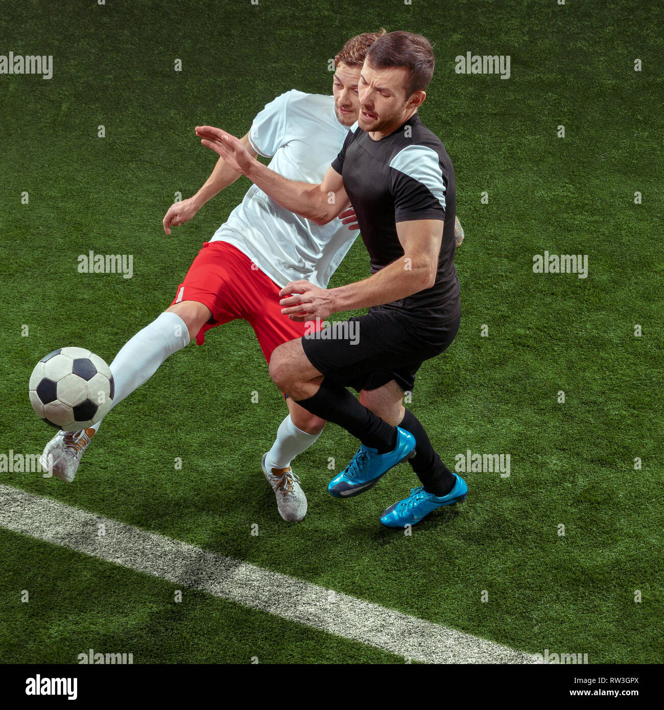Football player tackling for ball over green grass background