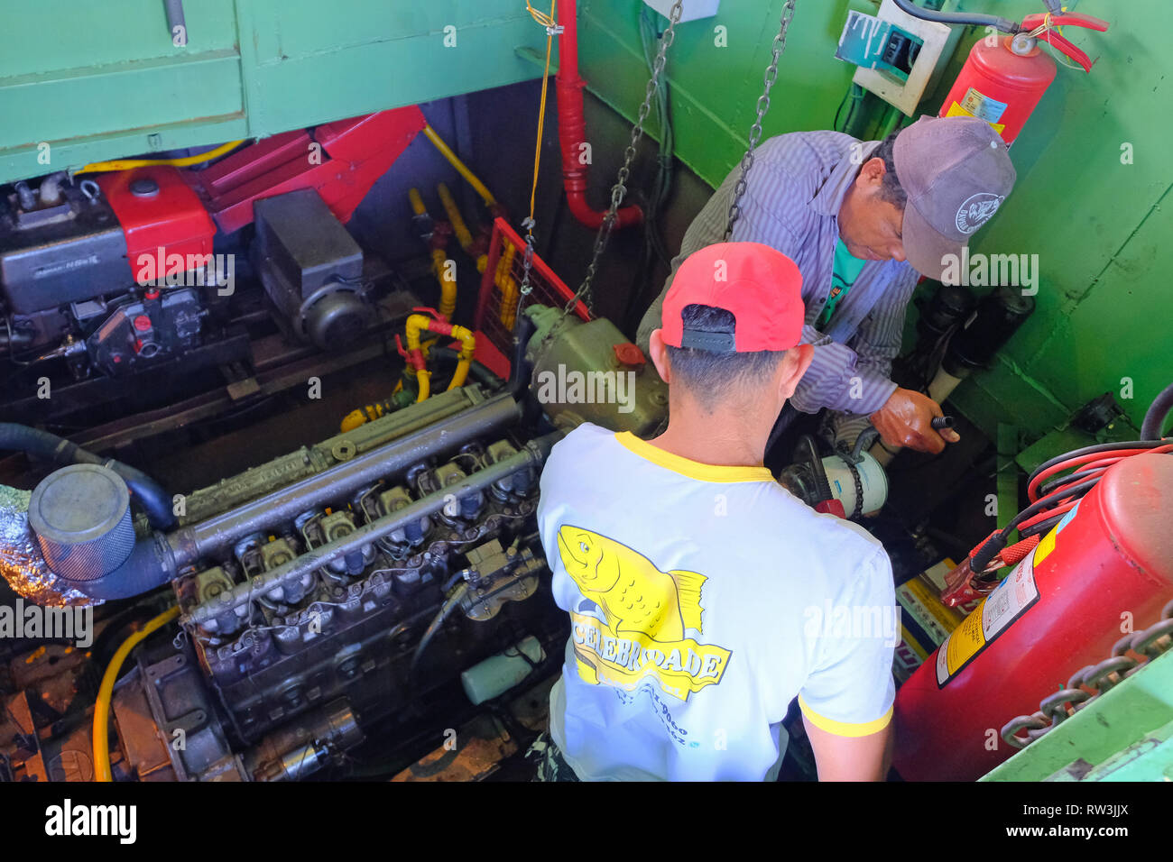 CORUMBA, MATO GROSSO, BRAZIL, JULY 22, 2018: Mechanics fixing the engine on pontoon boat on Rio Paraguay, Pantanal Stock Photo
