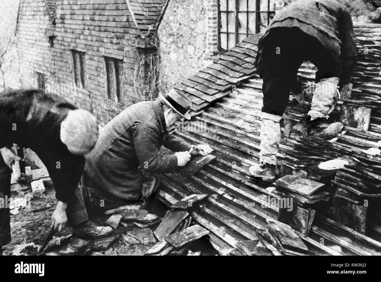 Winston Churchill assisting roofers with tiling at Chartwell. February 1939 Stock Photo