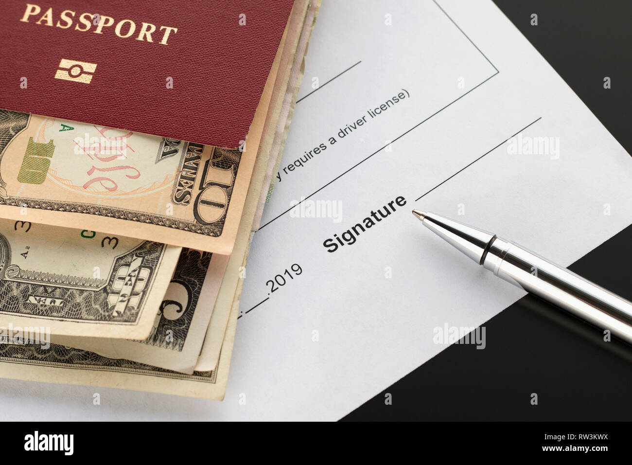 Signing a document, space for signature Passport with banknotes, pen. Topics of cash reward, insurance compensation, financial compensation Stock Photo