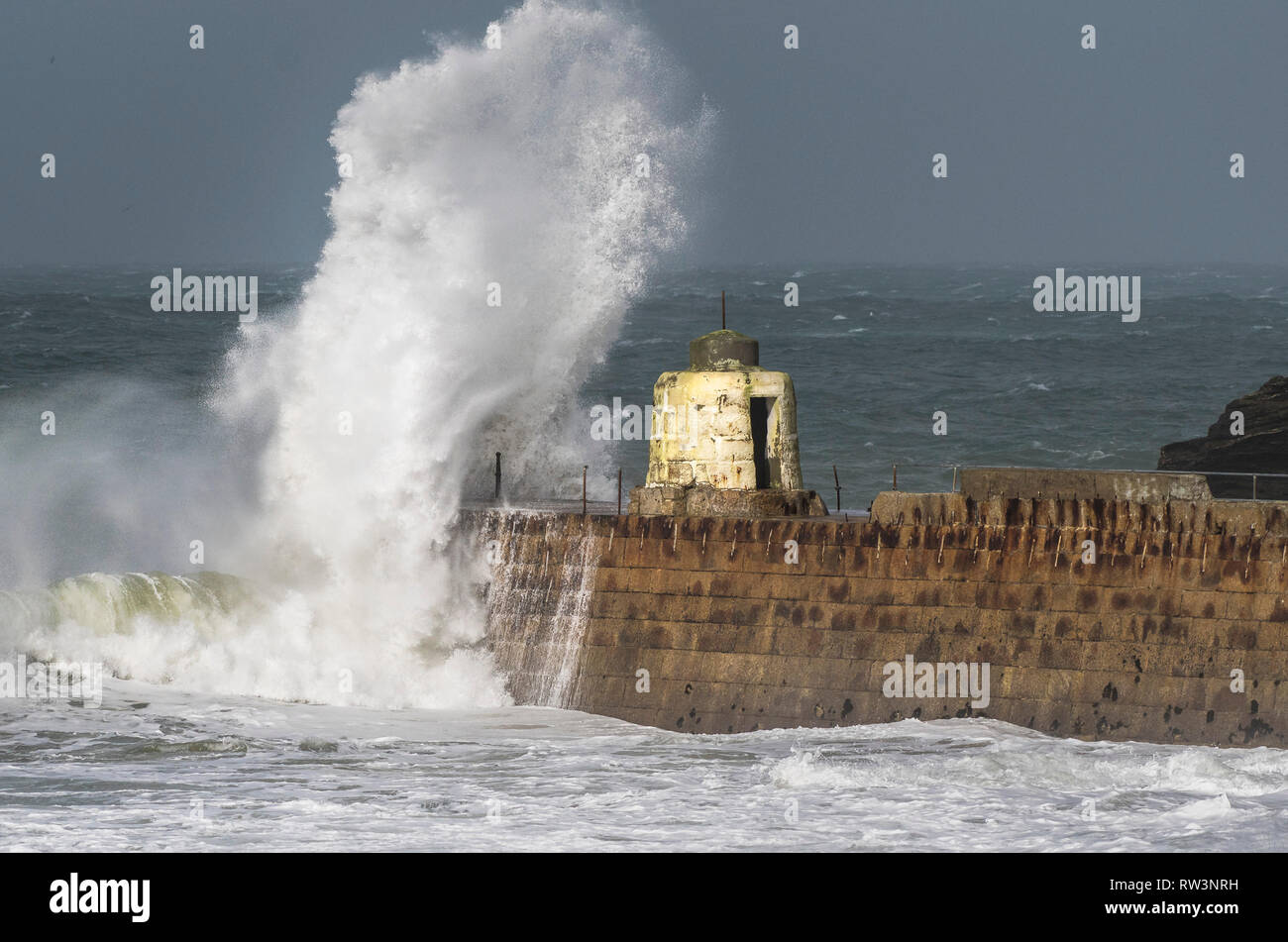 Storm Freya battering the Cornish coast with huge powerful waves breaking over the historic Monkey Hut on the pier at Portreath in Cornwall. Stock Photo