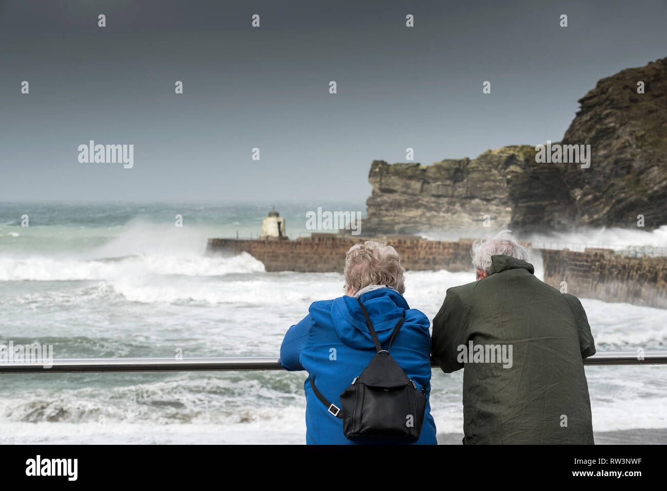 A mature couple watching the rough sea at Portreath in Cornwall. Stock Photo