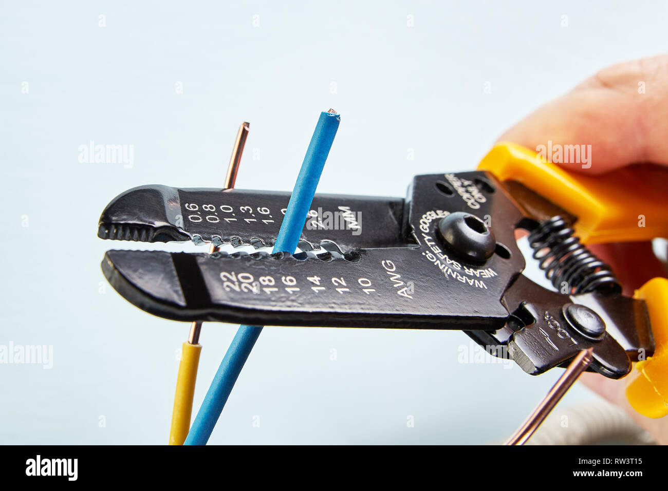 The electrician uses a cutter for stripping wires during electrical work,  close-up Stock Photo - Alamy