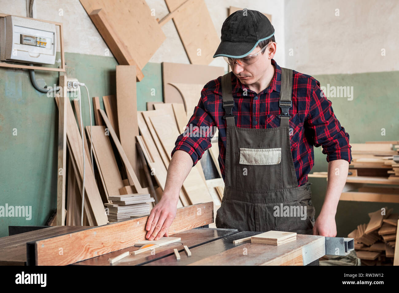 Carpenter worker cutting wooden board Stock Photo