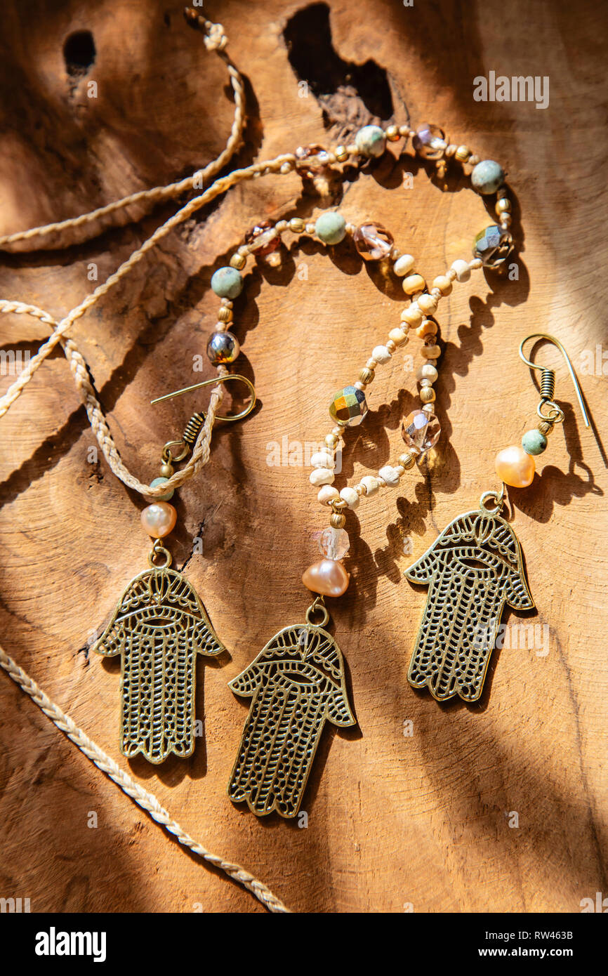 Jewelry set with Hamsa Fatima hand symbol and stone beads on wooden  background Stock Photo - Alamy