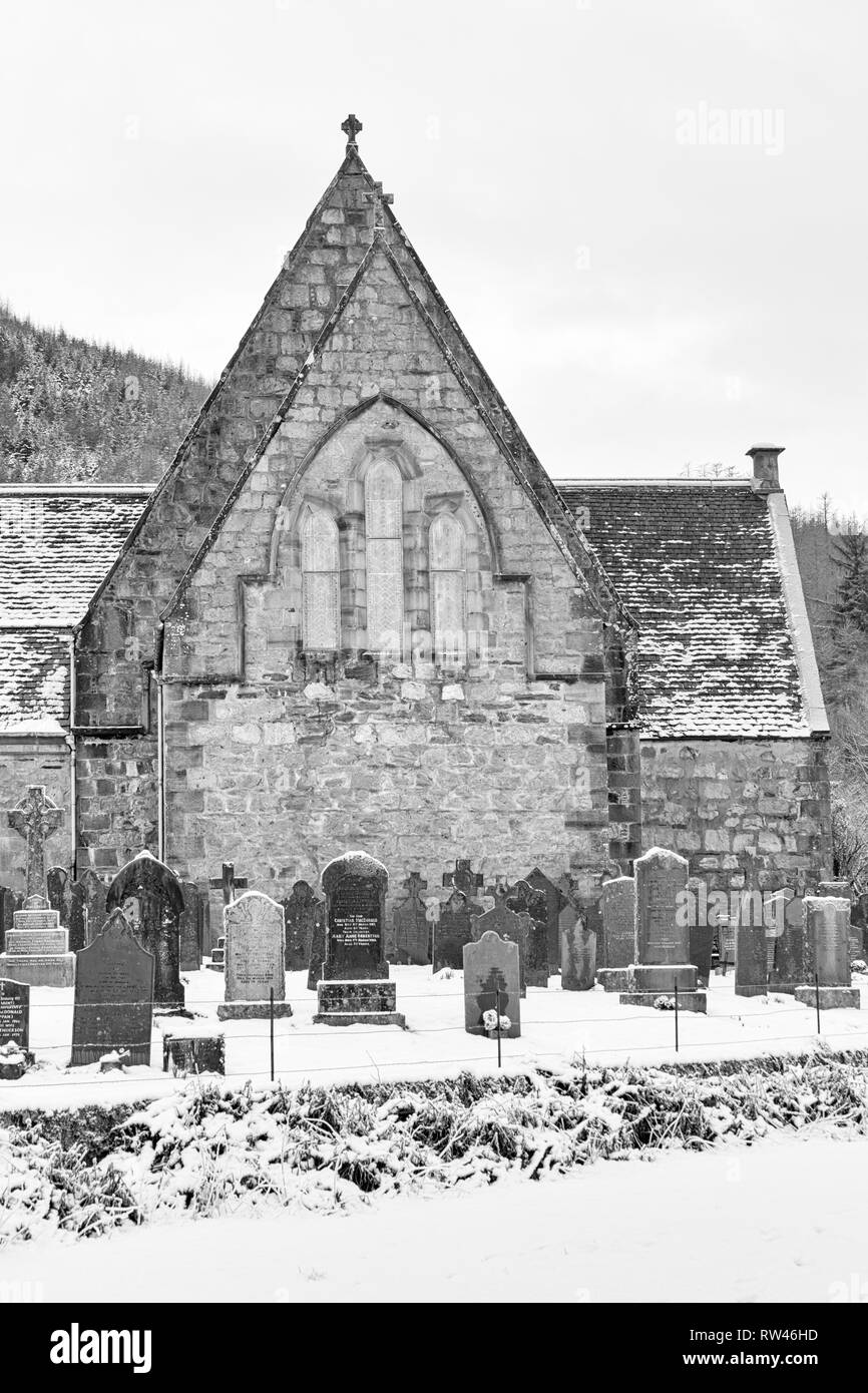 St John's Episcopal Church and gravestones in the snow at Ballachulish, Highlands, Scotland, UK on winters day in February - black & white monochrome Stock Photo