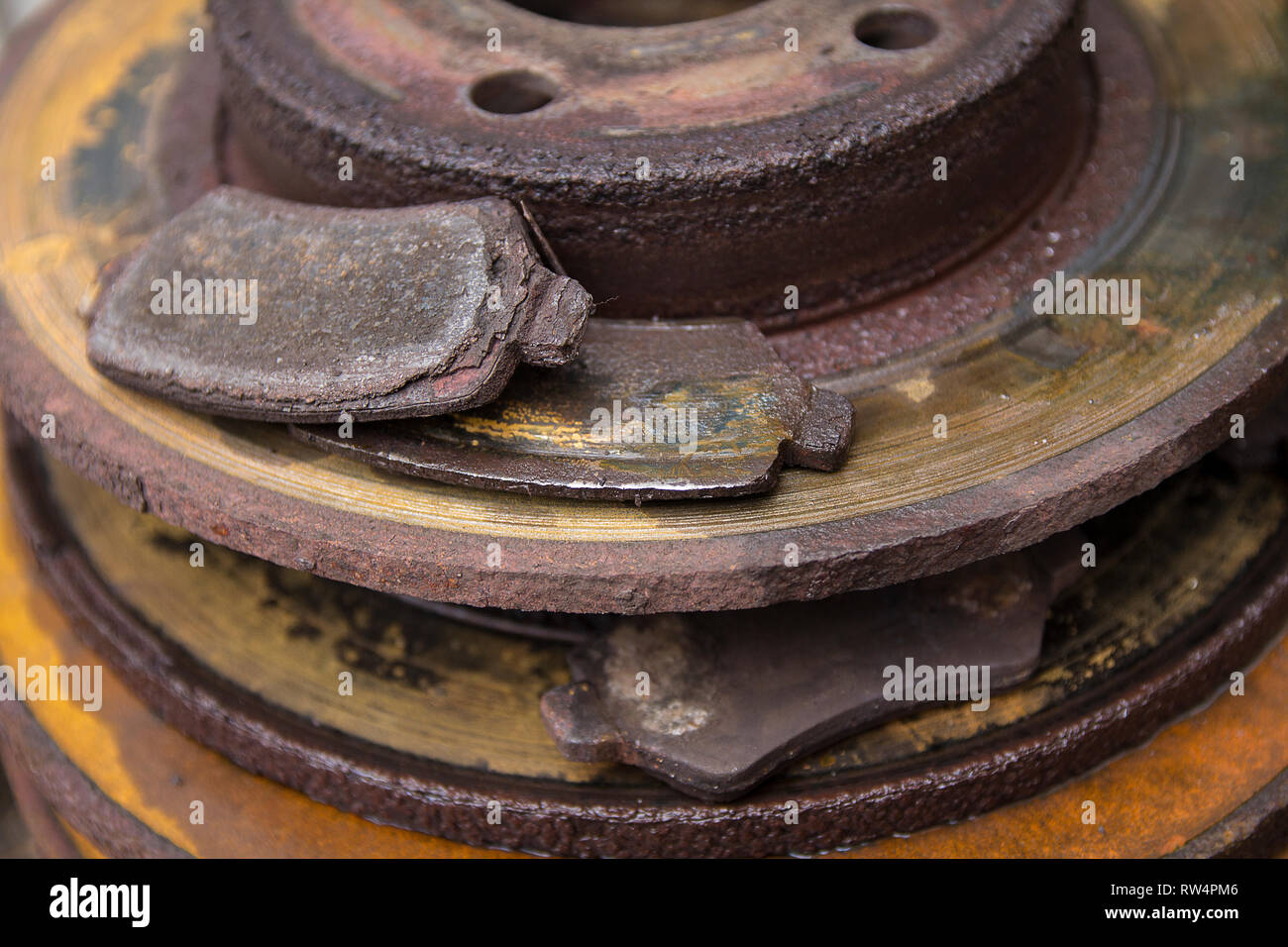 Car brake parts worn and rusty ready for recycling. The brake pads have little or no friction material left causing extra wear on the brake discs. Stock Photo