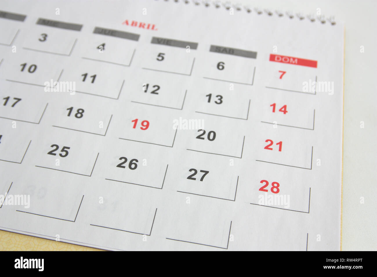 Calendar of the month of April on a table with some days in red to indicate  that they are holidays for the Holy Week Stock Photo - Alamy