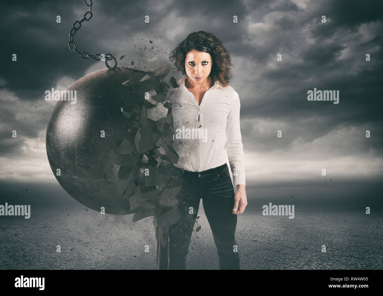 Power and determination of a young business woman against a wrecking ball Stock Photo